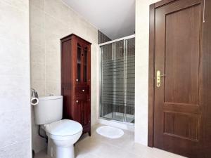 ein Badezimmer mit einem WC und einer Holztür in der Unterkunft Sueños de Monachil in Monachil