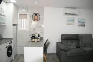 a living room with a couch and a kitchen at Bungalow en Los Balcones planta baja manzana 5 numero 18 in Alicante