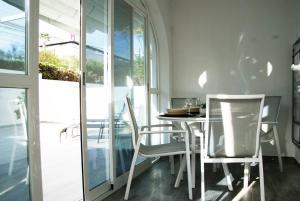 a dining room with white chairs and a table at Bungalow en Los Balcones planta baja manzana 5 numero 18 in Alicante