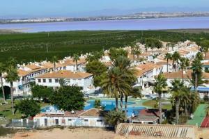 Vista ariale di un resort con piscina e palme di Bungalow en Los Balcones planta baja manzana 5 no 18 StayOrihuelaCosta #PRP004 ad Alicante