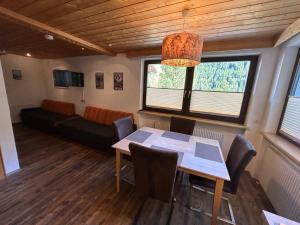 een kamer met een tafel en stoelen en een bank bij Appartements Max&Moritz in Kaunertal