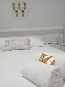 Una cama blanca con una manta blanca y plantas. en Sherryhouse, en Jerez de la Frontera