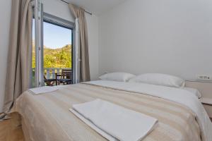 ein Schlafzimmer mit einem Bett mit einem großen Fenster in der Unterkunft Villa Stella Adriatica in Slano