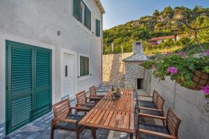 una mesa de madera y sillas en un patio en Villa Stella Adriatica, en Slano