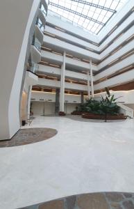 an empty lobby with a glass ceiling and plants at Or suite sea side Eilat - אור סויט סי סייד אילת in Eilat