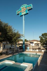 una piscina con un cartello per la locanda di San Francisco di Hotel Quinta San Carlos Inn a Manuel Valdez