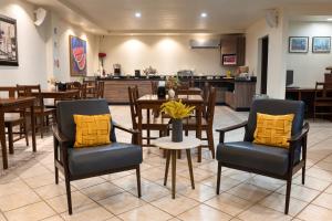 a dining room with chairs and tables and a kitchen at Hotel Quinta San Carlos Inn in Piedras Negras