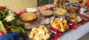a table with many different cakes and other desserts at Suites Bouganville ( casa 2) in Porto De Galinhas