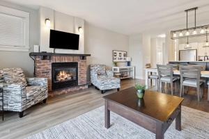 a living room with a fireplace and a dining room at 2 Bedroom Condo only steps to the Village! in Blue Mountains