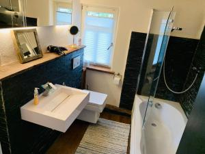 y baño con lavabo blanco y ducha. en 70 qm Studio mit Ausblick, en Gross-Umstadt