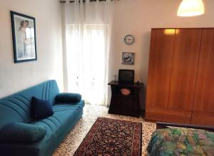 salon z niebieską kanapą i dużym oknem w obiekcie La casetta di Angela w mieście Lanciano