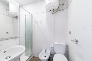 Un baño blanco con inodoro y lavabo. en Alohamundi Dúplex Alameda II, en Sevilla 13 fotos más
