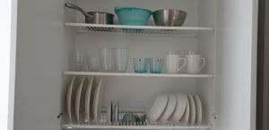 a shelf filled with dishes and cups and bowls at City apartment Pieksämaki in Pieksamaki