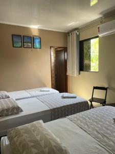 1 Schlafzimmer mit 2 Betten und einem Fenster in der Unterkunft HOTEL LISBOA in Capanema