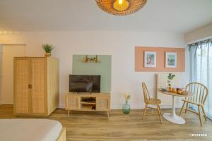 un soggiorno con TV, tavolo e sedie di Bel aparté, design, proche domaine universitaire Turly a Bourges