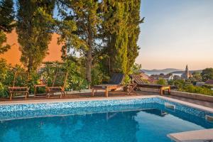 una piscina con sillas y vistas a la ciudad en Villa Stella Adriatica, en Slano