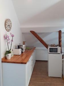 a kitchen with white cabinets and a clock on the wall at R-House in Braşov