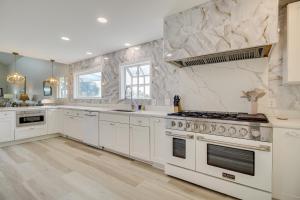 a large kitchen with white appliances and marble walls at Riverfront Savannah Retreat with Private Dock! in Savannah