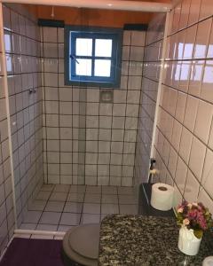 ein Bad mit einem Waschbecken, einem WC und einem Fenster in der Unterkunft Pousada Canto do Mar Ilha Grande in Praia de Araçatiba