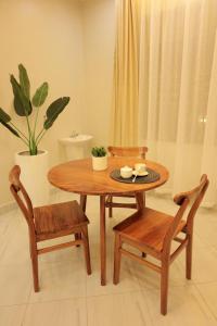 a wooden table with two chairs and a table with two cups at The residence Ug in Bulindo