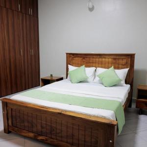 a bedroom with a large bed with green pillows at The residence Ug in Bulindo