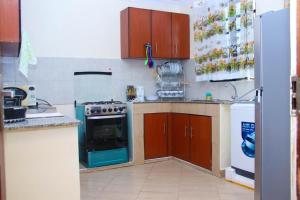 a kitchen with a stove and a refrigerator at PS' COMFORT HOMES in Kakamega