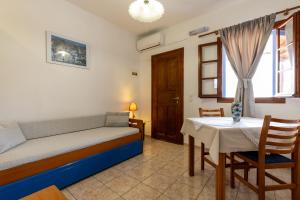a bedroom with a bed and a table and a window at Katerina Studios Mparou in Apollonia