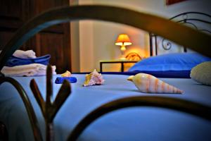 a bedroom with a bed with blue sheets and pillows at B&B L'Orizzonte in Castro di Lecce