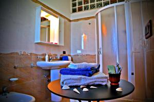 La salle de bains est pourvue d'un lavabo et de serviettes sur une table. dans l'établissement B&B L'Orizzonte, à Castro di Lecce