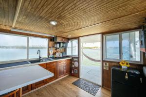 eine Küche mit Holzvertäfelung und Fenstern in einem Boot in der Unterkunft Beautiful Houseboat in Key West in Key West