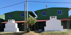 una casa verde e bianca con tetto rosso di Puerto del sol a Punta Del Diablo