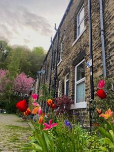 un edificio de ladrillo con flores delante en Heart of Hebden, en Hebden Bridge