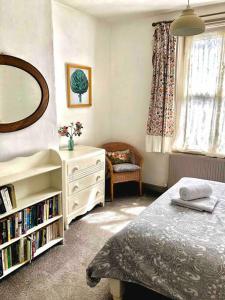 une chambre avec un lit, une commode et un miroir dans l'établissement Heart of Hebden, à Hebden Bridge