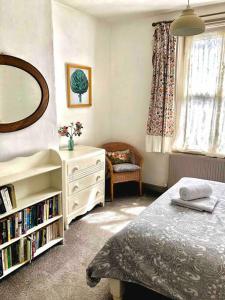 a bedroom with a bed and a dresser and a mirror at Heart of Hebden in Hebden Bridge