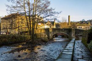 un pont en pierre sur une rivière dans une ville dans l'établissement Heart of Hebden, à Hebden Bridge