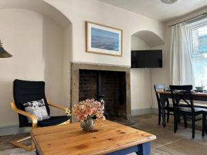 a living room with a table and a fireplace at Heart of Hebden in Hebden Bridge