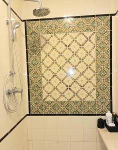 a bathroom with a shower with a tiled wall at Dar Meriem in Tunis