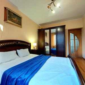ein Schlafzimmer mit einem großen Bett mit einer blauen Decke in der Unterkunft Новобудова 2 кімнати Вернадського 8 in Lwiw