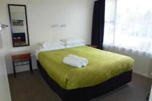 Una habitación de hotel con una cama con toallas. en ASURE Adcroft Motel, en Ashburton