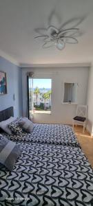a bedroom with a large bed with a ceiling fan at Bella Vista 414-Ocean Lanzamar- Puerto Del Carmen in Tías