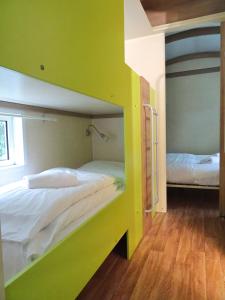 two bunk beds in a room with green walls at La Roulotte à 10min de Disneyland Paris - Cabane & Cabanon in Chalifert