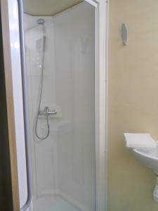 W łazience znajduje się szklana kabina prysznicowa i umywalka. w obiekcie La Roulotte à 10min de Disneyland Paris - Cabane & Cabanon w mieście Chalifert