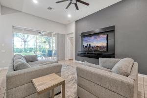 uma sala de estar com 2 sofás e uma televisão de ecrã plano em Windsor Hills 4BR's Mickeys Ranch Near Disney em Orlando