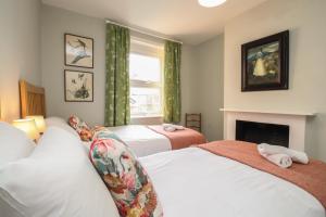 une chambre avec deux lits et une cheminée dans l'établissement The Corner House, à Weymouth