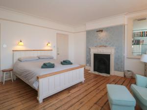 a bedroom with a white bed and a fireplace at 49 Esplanade in Burnham on Sea