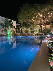 uma piscina à noite com luzes em Kai'ala Pousada em São Miguel do Gostoso