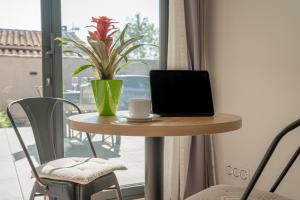 una mesa con ordenador portátil y una taza de café. en chez pascal et olivier, en Saint-Chamas