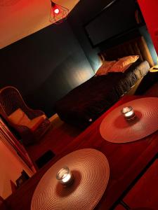 a room with a bed and two large hats on the floor at Secrète loft, spa & jaccuzi privatif - parking & bien-être près de Toulouse in Aucamville