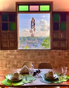 a dining room table with a view of a window at Pousada do Tom in Lençóis
