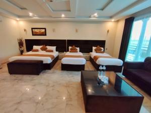 a hotel room with two beds and a couch at Swat Hilton Hotel by Khan Familia in Swat